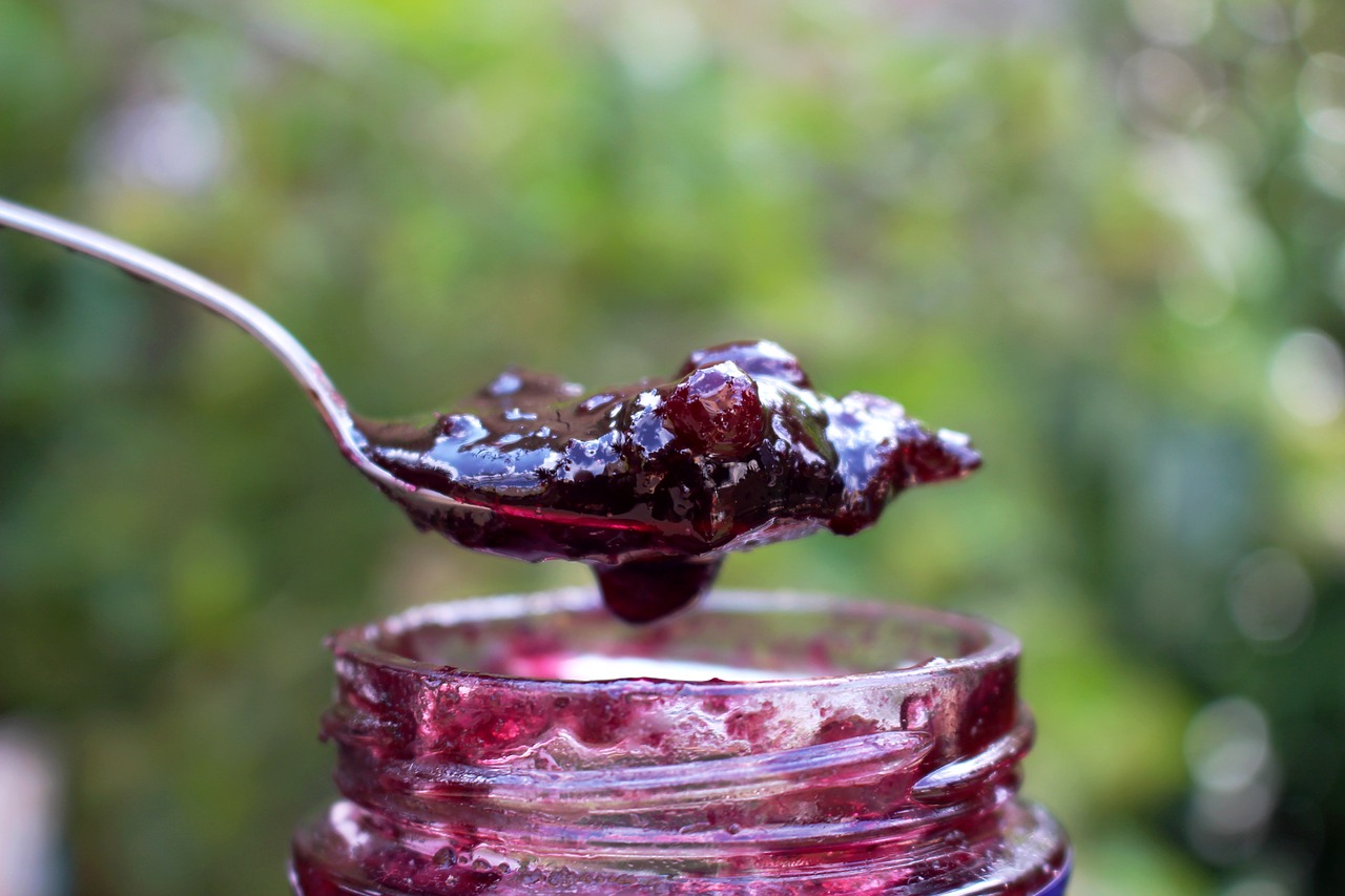 Blackberry jam Heaping spoonful of blackberry jam over a jar.